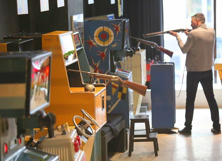 Посетитель музея советских игровых автоматов во время стрельбы из винтовки